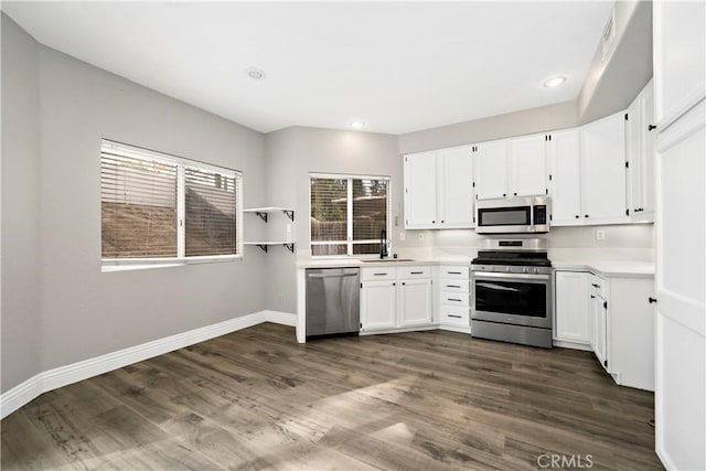 kitchen with dark hardwood / wood-style floors, appliances with stainless steel finishes, white cabinetry, and sink