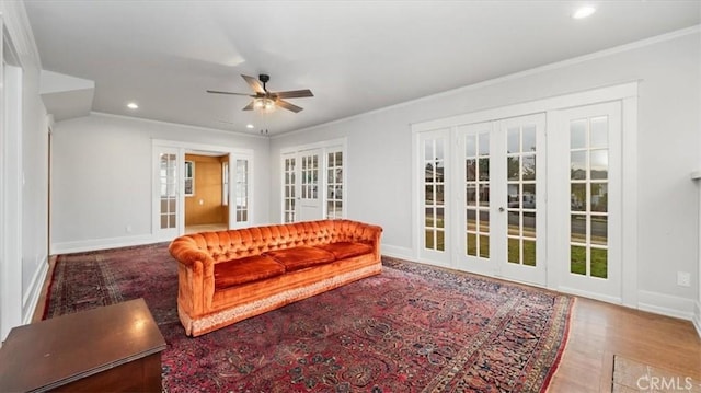 living room featuring hardwood / wood-style floors, ceiling fan, ornamental molding, and french doors