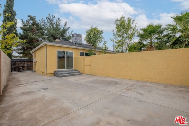 rear view of property featuring a patio and central AC