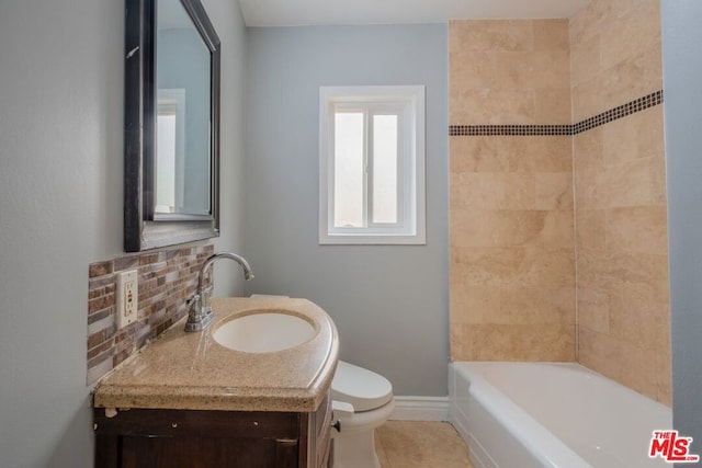 full bathroom with tasteful backsplash, vanity, tiled shower / bath, and toilet