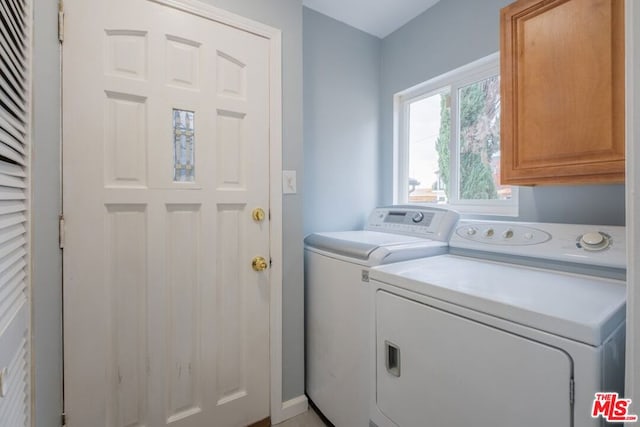 washroom featuring cabinets and washing machine and clothes dryer