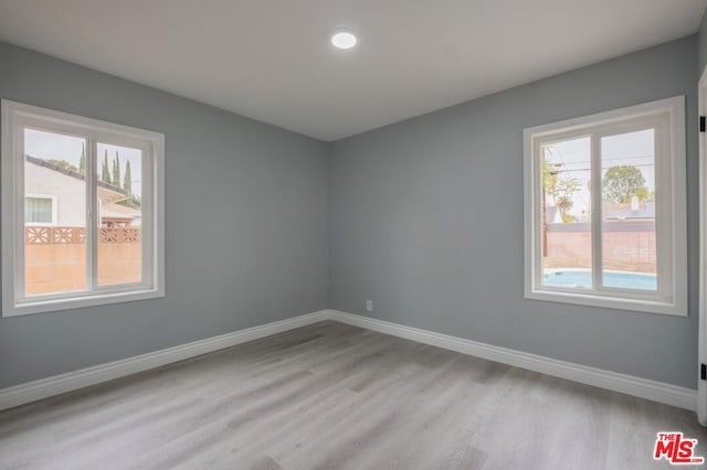 empty room with light hardwood / wood-style flooring and a wealth of natural light