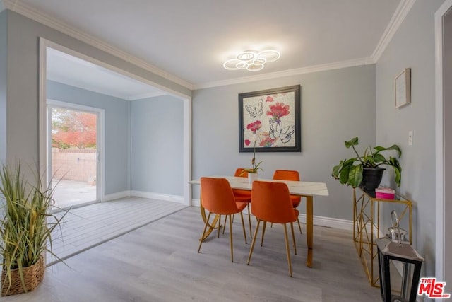 dining area with light hardwood / wood-style flooring and ornamental molding