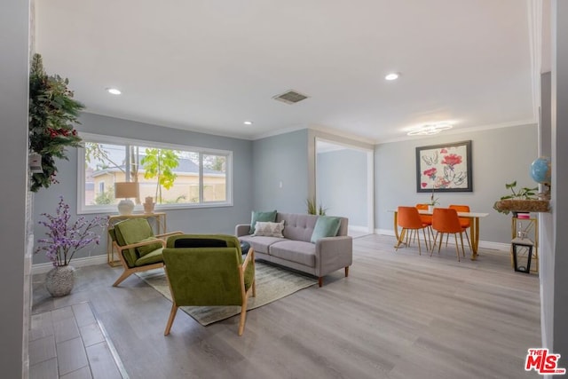 living room with crown molding and light wood-type flooring