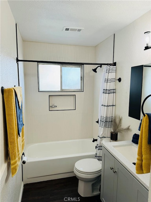 full bathroom featuring vanity, wood-type flooring, a textured ceiling, and a wealth of natural light