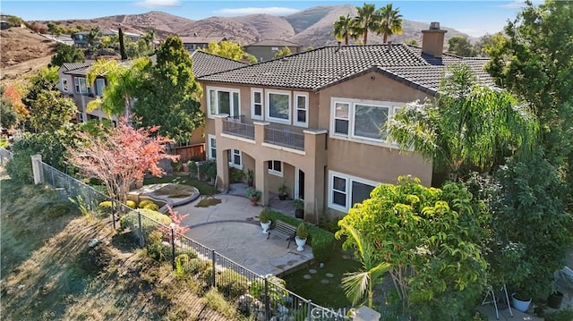 back of house featuring a mountain view and a patio