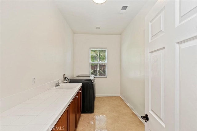 laundry area with cabinets, hookup for a washing machine, and sink