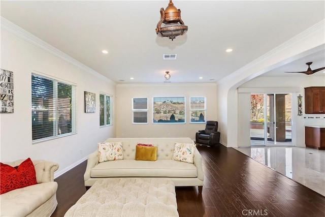 living room featuring ornamental molding, dark wood-type flooring, and ceiling fan