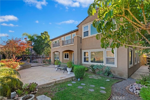 back of property featuring a patio and a balcony