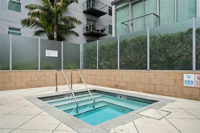 view of swimming pool featuring a hot tub