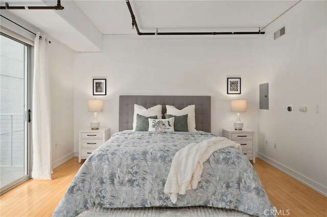 bedroom featuring electric panel and light hardwood / wood-style flooring