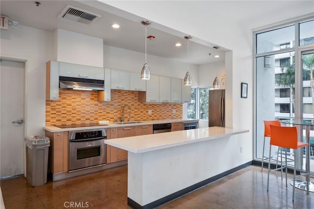 kitchen featuring sink, stainless steel appliances, tasteful backsplash, and white cabinetry