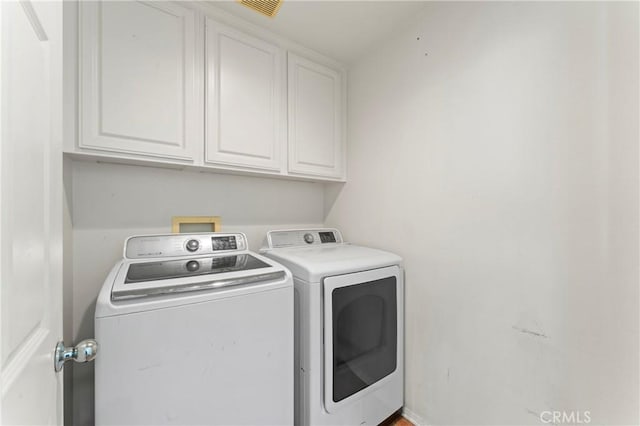 washroom featuring cabinets and separate washer and dryer