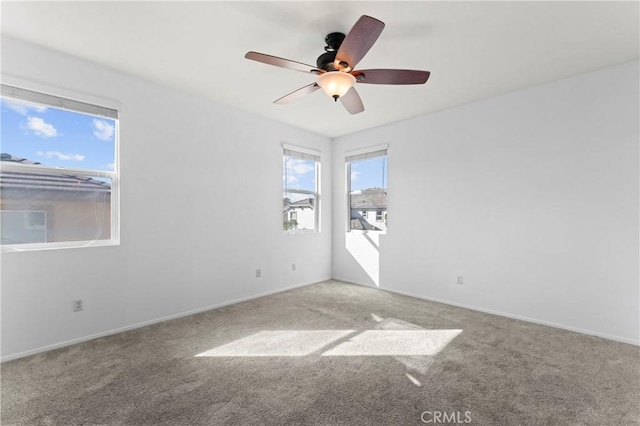 carpeted spare room featuring ceiling fan