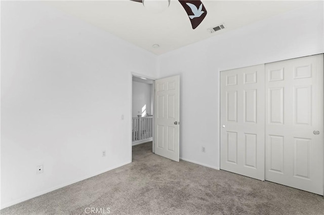 unfurnished bedroom with ceiling fan, a closet, and light colored carpet