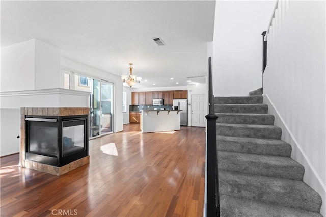 interior space with a multi sided fireplace, dark hardwood / wood-style floors, and an inviting chandelier