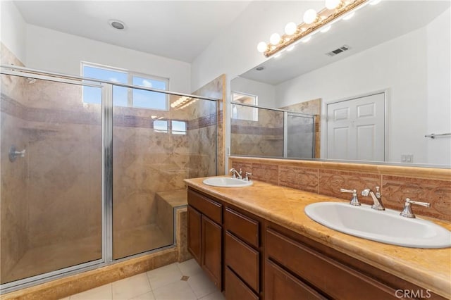 bathroom with tile patterned flooring, decorative backsplash, vanity, and walk in shower