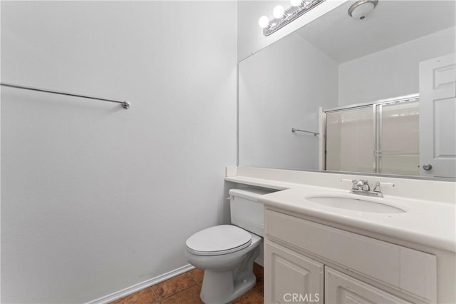 bathroom with tile patterned flooring, vanity, toilet, and a shower with shower door