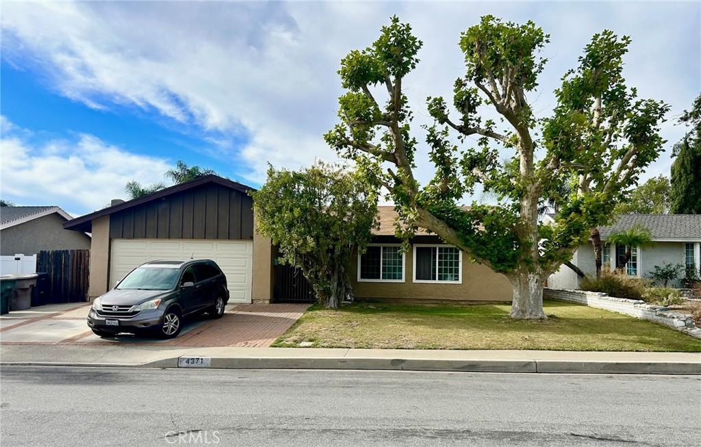 single story home with a front yard and a garage