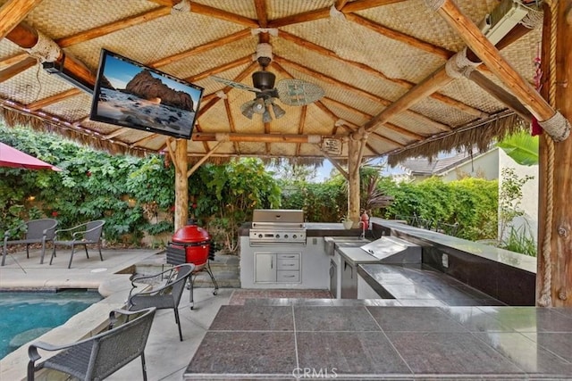 view of patio featuring a gazebo, an outdoor kitchen, grilling area, and ceiling fan