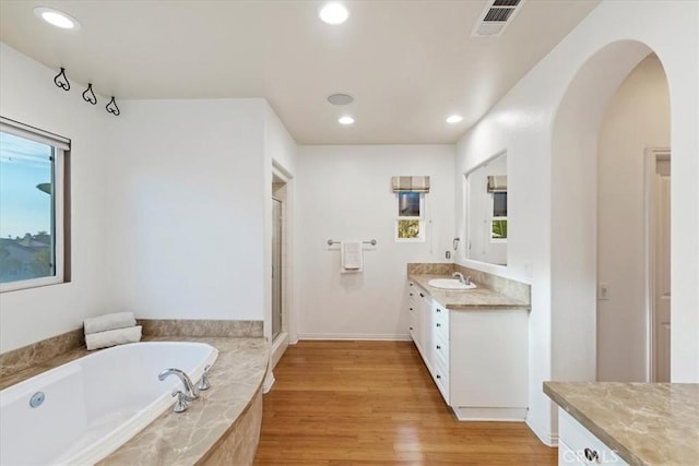 bathroom featuring shower with separate bathtub, vanity, hardwood / wood-style flooring, and a healthy amount of sunlight