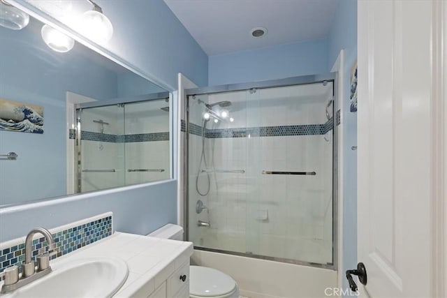 full bathroom with vanity, toilet, enclosed tub / shower combo, and backsplash