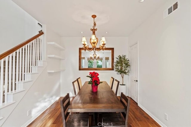 dining room with dark hardwood / wood-style flooring and an inviting chandelier