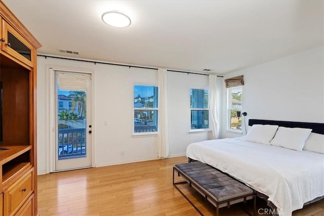 bedroom with access to exterior and light wood-type flooring