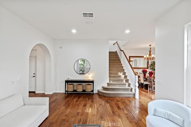 living room with hardwood / wood-style flooring and a notable chandelier