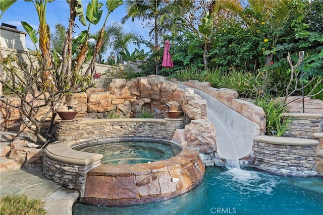 view of pool with an in ground hot tub