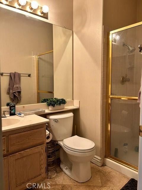 bathroom featuring tile patterned floors, vanity, toilet, and walk in shower