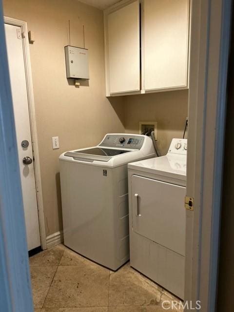 laundry room featuring cabinets, independent washer and dryer, and light tile patterned flooring