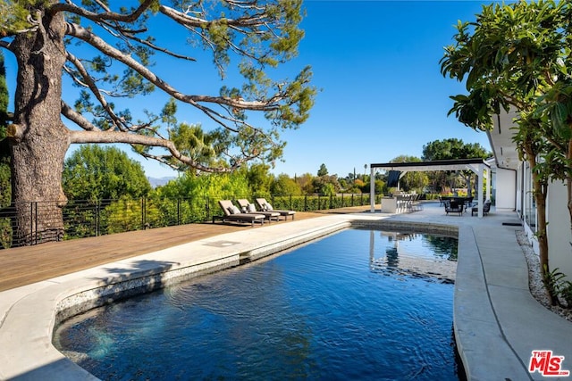 view of swimming pool featuring a deck and a patio