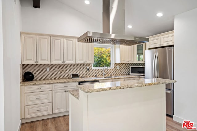 kitchen with sink, a center island, stainless steel appliances, island exhaust hood, and light wood-type flooring