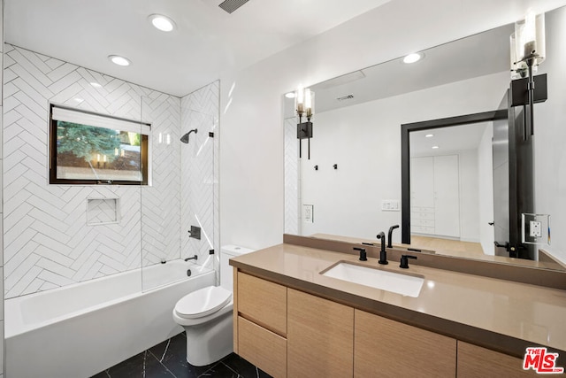 full bathroom with vanity, tiled shower / bath combo, and toilet