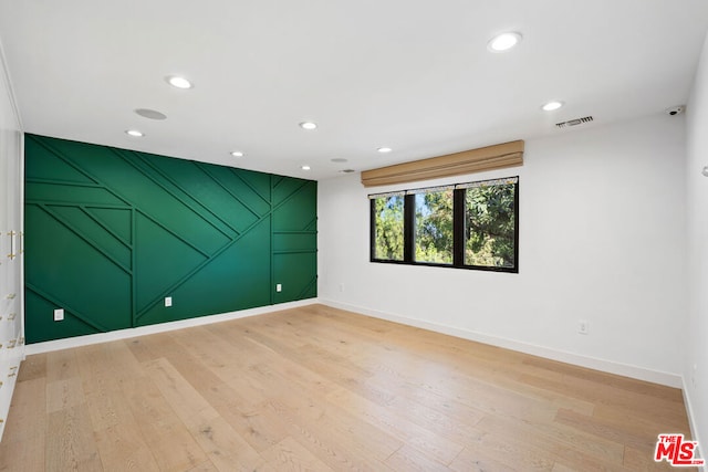 spare room with wood-type flooring