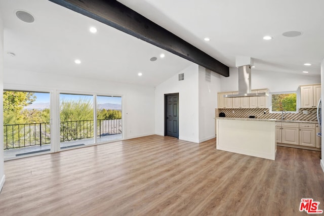 unfurnished living room with vaulted ceiling with beams, sink, and light wood-type flooring