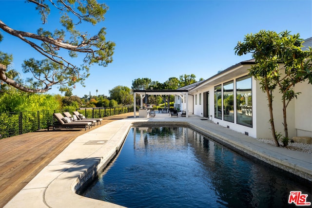 view of pool with outdoor lounge area and a wooden deck