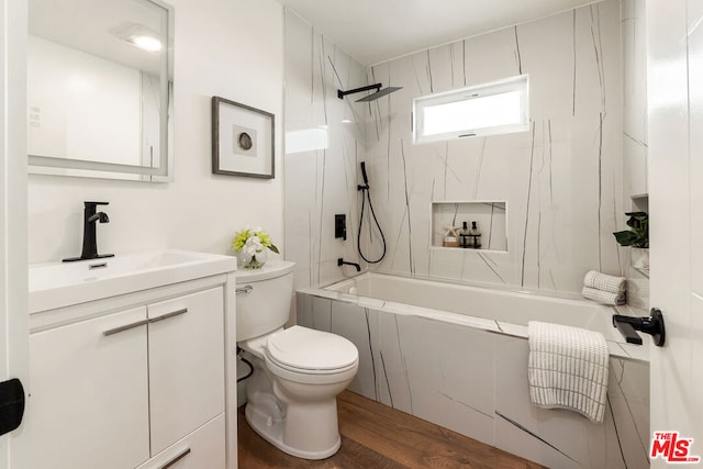 full bathroom featuring vanity, hardwood / wood-style floors, toilet, and tiled shower / bath