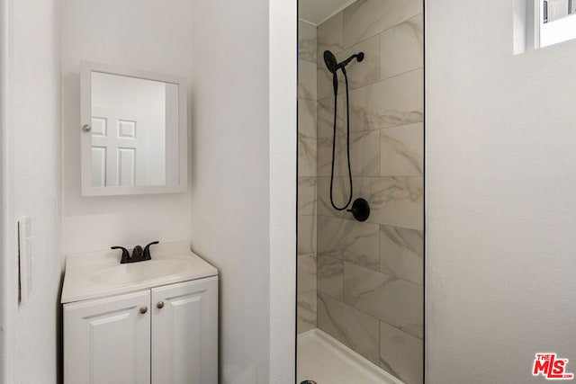 bathroom with vanity and tiled shower