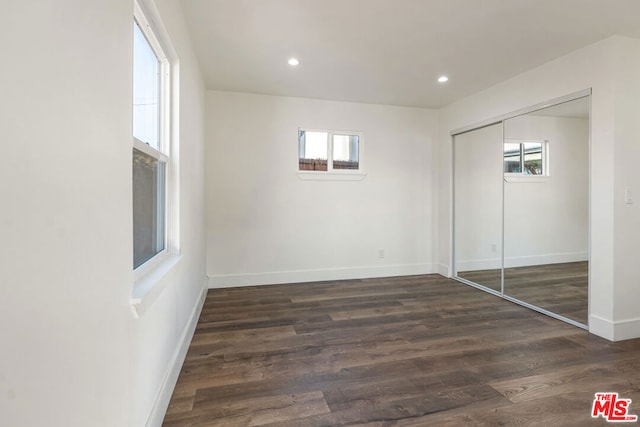 unfurnished bedroom with a closet and dark hardwood / wood-style floors