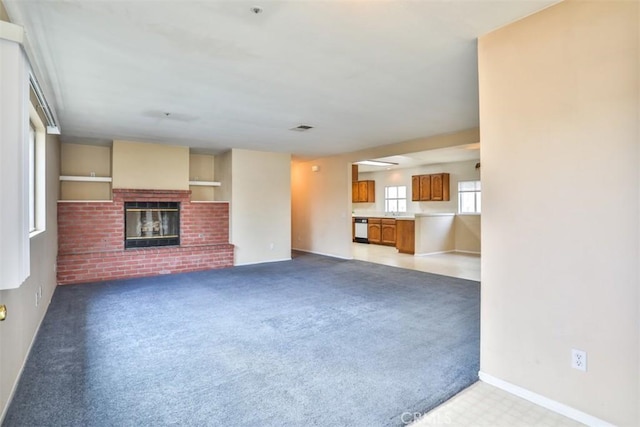 unfurnished living room with carpet floors and a fireplace