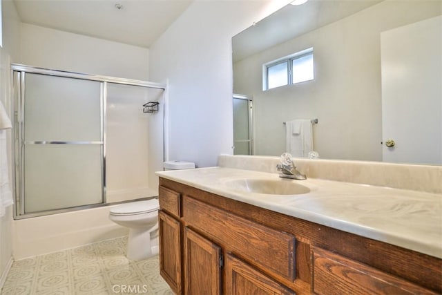 full bathroom with combined bath / shower with glass door, vanity, and toilet