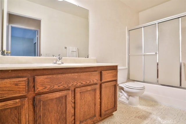 full bathroom with vanity, toilet, and bath / shower combo with glass door