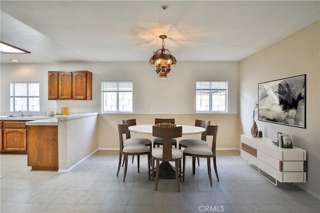 dining area featuring a chandelier, sink, and a healthy amount of sunlight