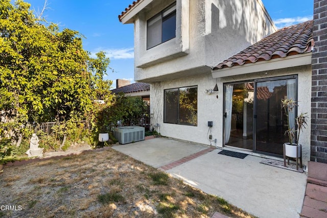 rear view of house with central AC unit and a patio area