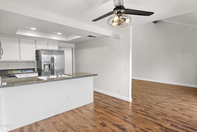 kitchen featuring sink, a tray ceiling, white cabinets, stainless steel fridge with ice dispenser, and kitchen peninsula