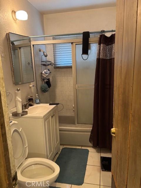 full bathroom featuring tile patterned floors, vanity, toilet, and enclosed tub / shower combo