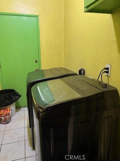 washroom with light tile patterned floors and washing machine and clothes dryer