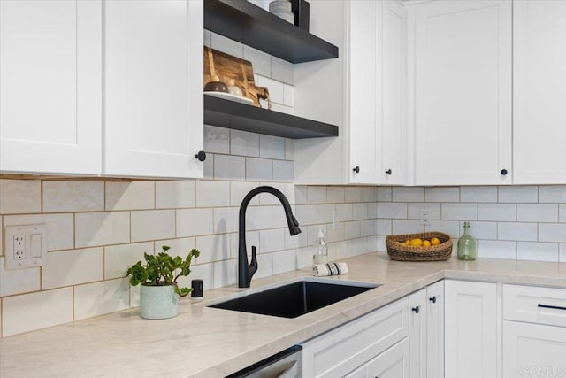 kitchen featuring white cabinets, sink, and tasteful backsplash